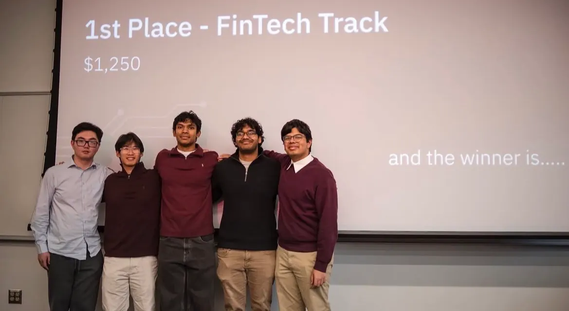 The first-place FinTech track team in front of the winner announcement slide